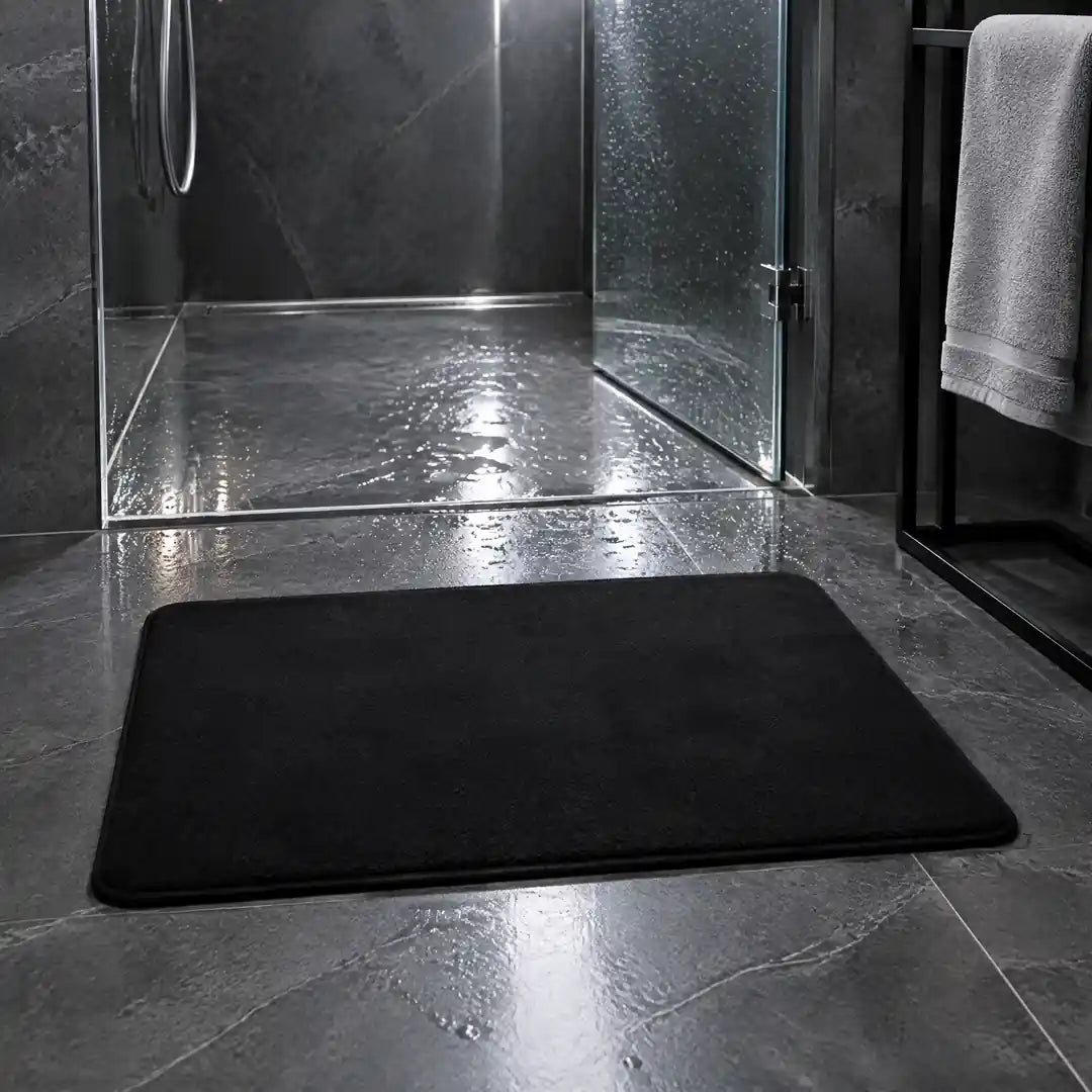 Schwarze Badematte liegt plan vor einer bodengleichen Dusche