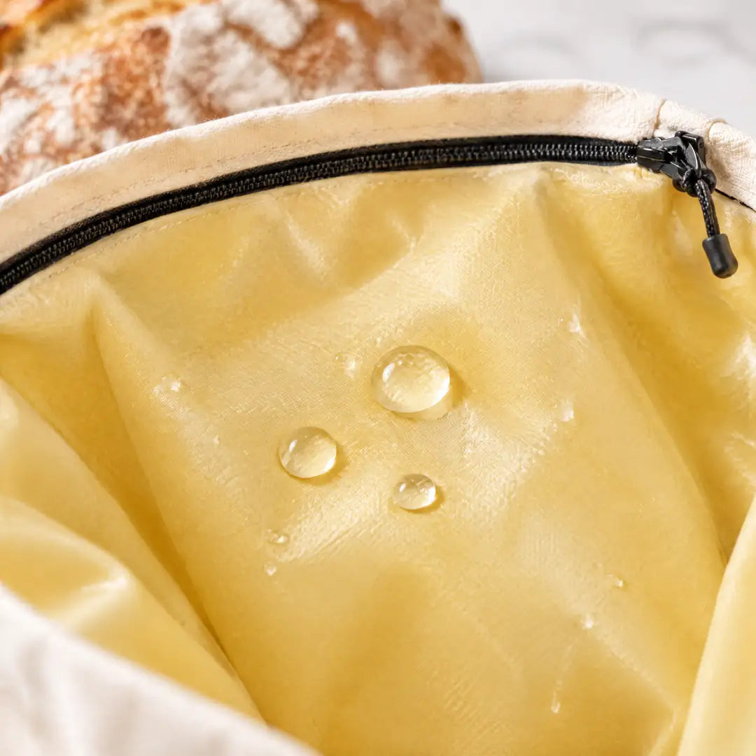 Wassertropfen perlen auf dem Bienenwachs-Futter des Brotbeutels ab