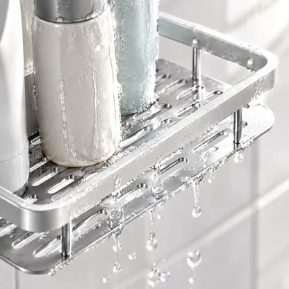 Wasser läuft durch den gelochten Boden der silbernen Duschablage