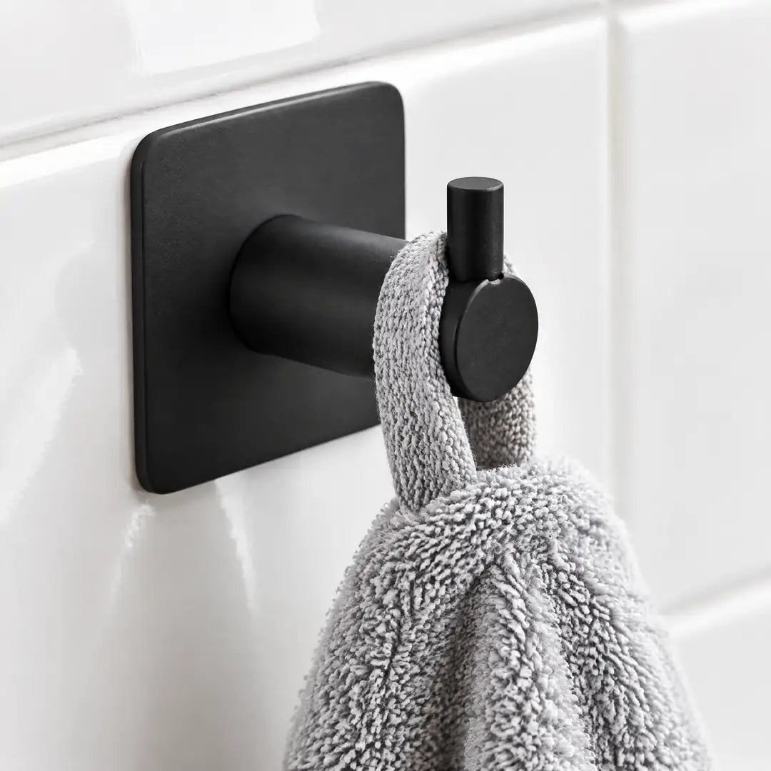 Handtuchschlaufe wird von der hochgezogenen Spitze des schwarzen Hakens gehalten