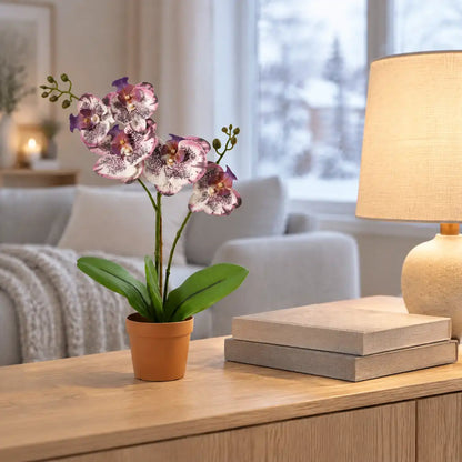 Künstliche Orchidee in Lila auf einem Sideboard im winterlichen Wohnzimmer