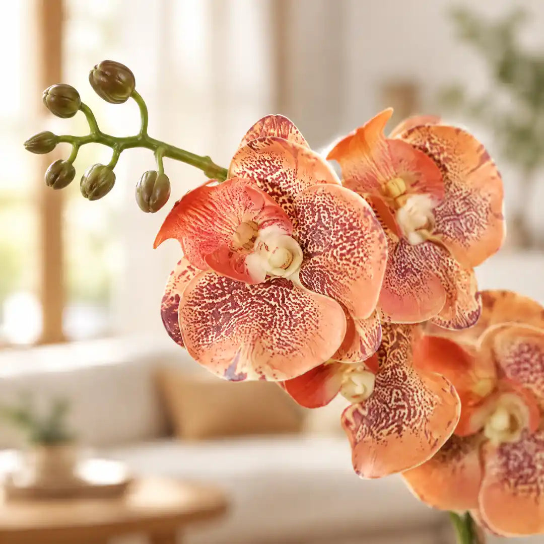 Nahaufnahme der gesprenkelten Blüten der künstlichen Orchidee in Orange