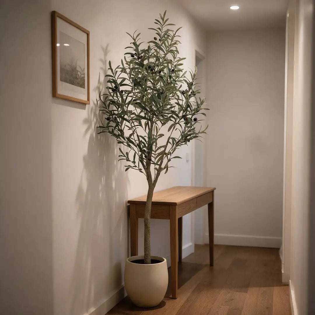 Künstlicher Olivenbaum in einem fensterlosen Flur neben einer schmalen Konsole