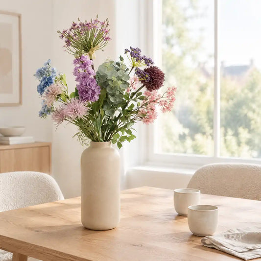 Kunstblumenstrauß in beiger Vase auf dem Esstisch im hellen Wohnraum