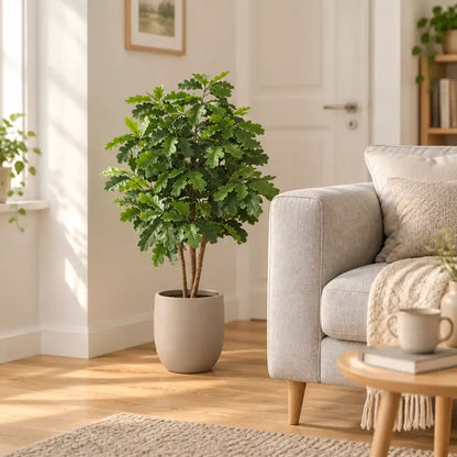 Künstliche Eiche im beigen Übertopf neben dem Sofa im Wohnzimmer