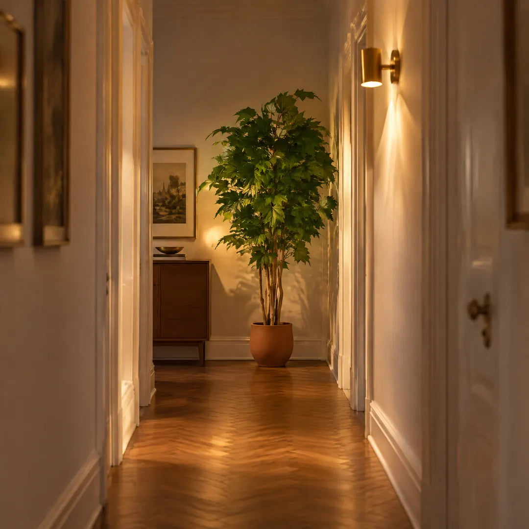 Künstlicher Ahornbaum am Ende eines fensterlosen Flurs im warmen Lampenlicht