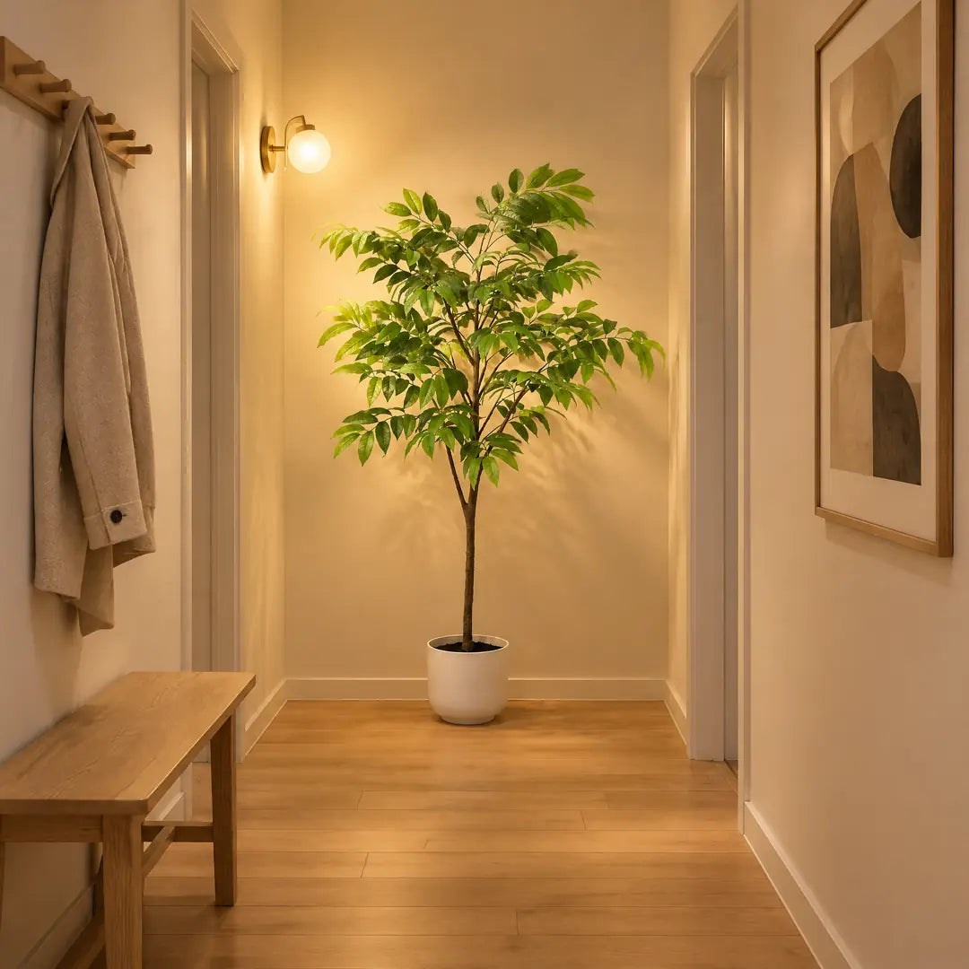 Tropischer Kunstbaum in einem fensterlosen Flur mit warmer Wandleuchte