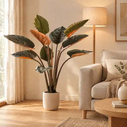 Künstlicher Philodendron mit roten Blättern neben einem Leinensofa im Wohnzimmer