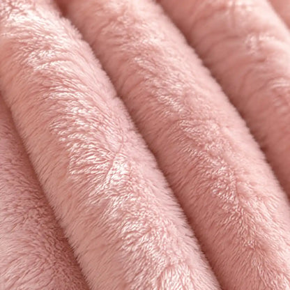 Nahaufnahme des Korallenfleece-Flors der rosafarbenen Kuscheldecke