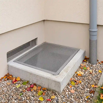 Hausecke mit drei durch Edelstahlgitter verschlossenen Öffnungen