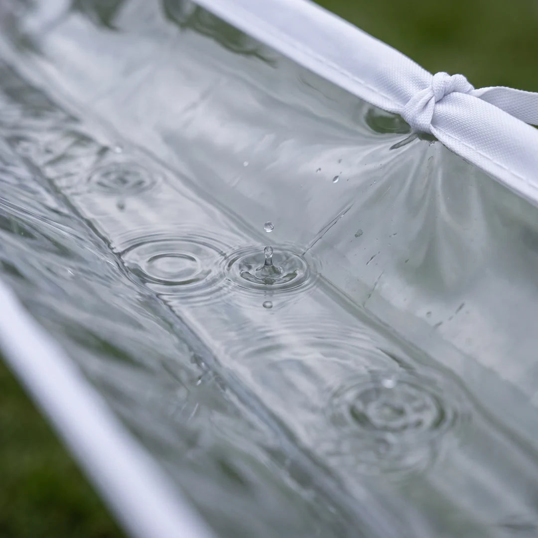 Nahaufnahme: Regenwasser sammelt sich in der transparenten PVC-Mulde