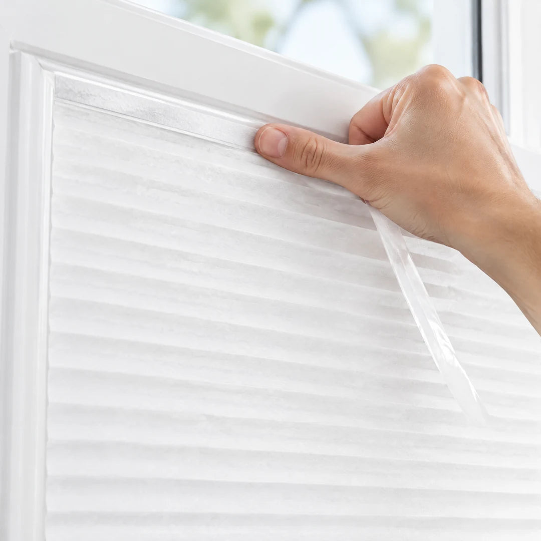 Klebestreifen des Plissees wird am Fensterrahmen angedrückt