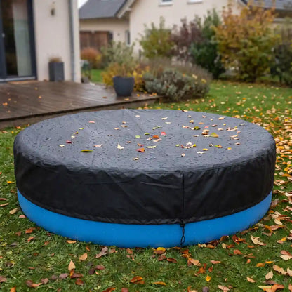 Abgedeckter Pool im herbstlichen Garten, Laub und Regentropfen auf der schwarzen Poolplane