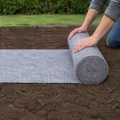 Rasenmatte wird im Garten auf vorbereiteter Erde ausgerollt